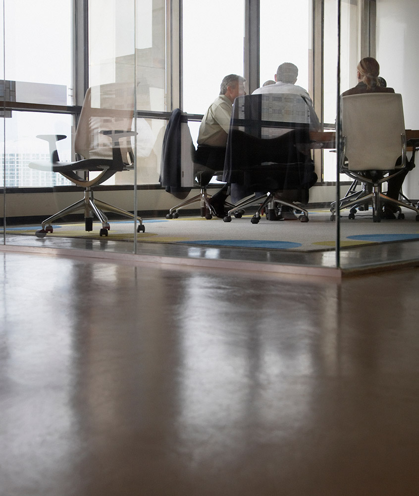 5 people sitting at a conference table during a meeting
